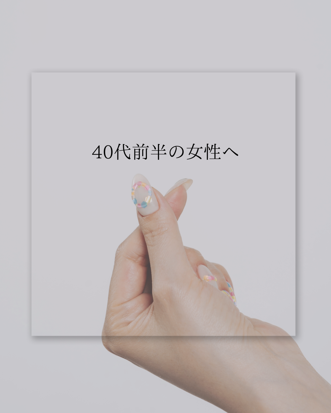 40代前半の女性へ」というメッセージが書かれたシンプルなデザインの画像。カラフルなネイルを施した手が優しく添えられている。